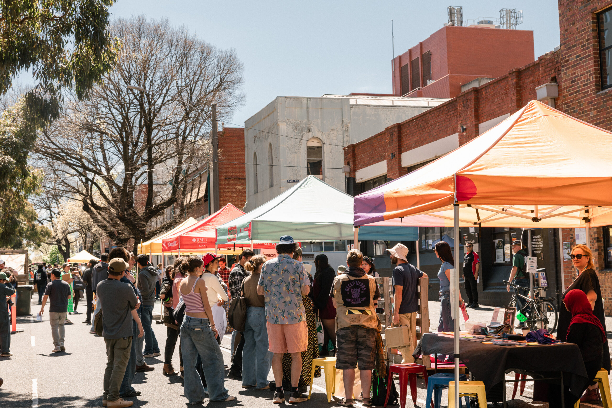 A group of people standing around tents at a street festival/