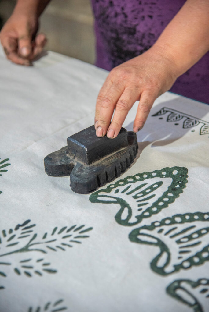 Womans hand working with fabric printing mold and ink traditional writing and woodblock printing work of Kastamonu and Anatolia region.